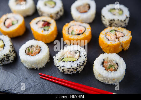 Sushi-Rollen mit Stäbchen Stockfoto