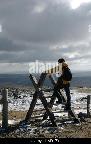 Hill-Walker großen hölzernen Stil an bewölkten Tag mit lückenhaft Schnee über Zaun klettern Stockfoto