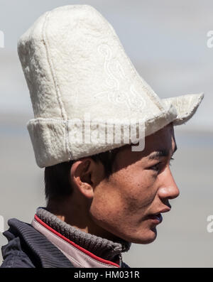 Kirgisischen Mann in traditionellen Hut Posen in bergigen Landschaft der Pamir-Hochebene von der Karakorum Highway, Xijiang, China. Stockfoto