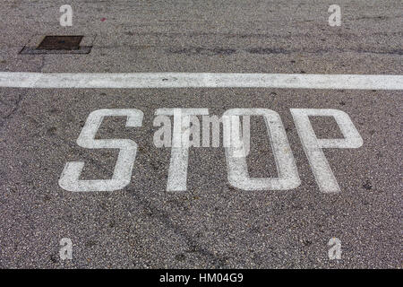 Wort zu stoppen, geschrieben auf asphaltierter Strasse, Draufsicht auf der Straße in der Perspektive Stockfoto