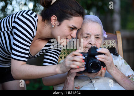 junges Mädchen zeigt Bilder zu Oma auf Foto-Kamera Stockfoto