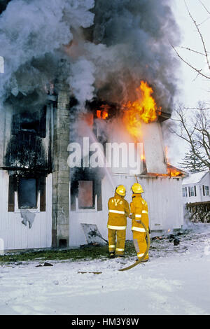 Zwei Feuerwehrleute kämpfen einen Hausbrand in Ascutney, VT, USA. Digitale Dia-Scan. Stockfoto