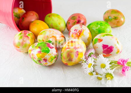 Bemalte Ostereier und Daisy Blumen in voller Blüte Stockfoto