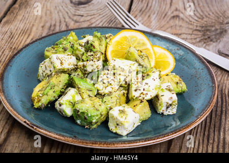 Salat mit Ziegenkäse Käse, Avocado und Olive Öl auf Holz Hintergrund Stockfoto