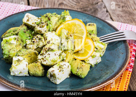 Salat mit Ziegenkäse Käse, Avocado und Olive Öl auf Holz Hintergrund Stockfoto