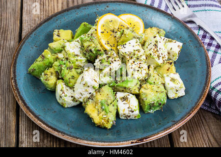 Salat mit Ziegenkäse Käse, Avocado und Olive Öl auf Holz Hintergrund Stockfoto