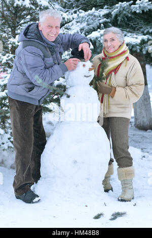 älteres paar machen Schneemann Stockfoto