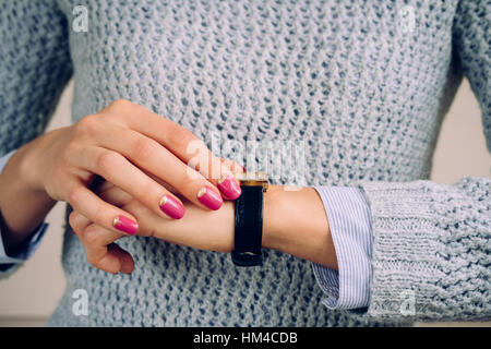 Goldene Uhr mit einem Lederband auf eine weibliche Hand. Stockfoto