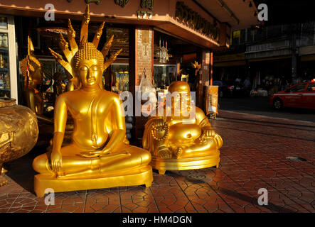 Große goldene Buddha-Statuen vor Geschäft in Bangkok Stockfoto