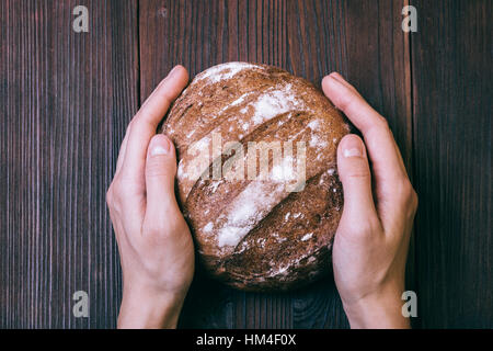 Nahaufnahme der weiblichen Hände gelegt auf dem Tisch von frischem Brot, Ansicht von oben Stockfoto