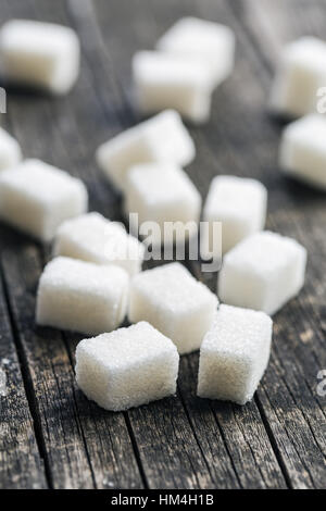 Weiße Zuckerwürfel auf alten Holztisch. Stockfoto