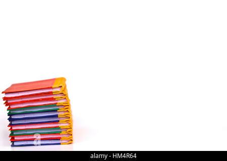 Bunte Bücherstapel auf weißem Hintergrund, Teilansicht. Stockfoto