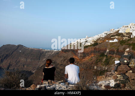 Ein paar sitzt auf Skaros Felsen, Santorini, Griechenland Stockfoto