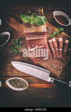 In Scheiben geräuchertem Schweinefleisch auf Holzbrett Stockfoto