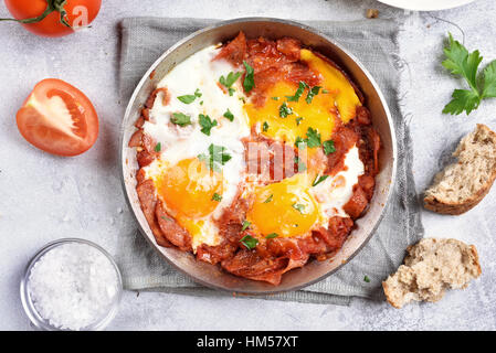 Spiegeleier mit Tomaten und Speck in Pfanne, Ansicht von oben, Nahaufnahme Stockfoto