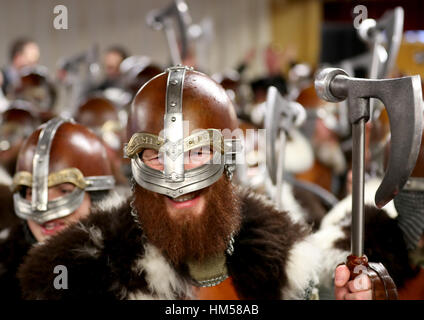 Mitglieder der Jarl Kader gekleidet in Viking Anzüge Halt an der Royal British Legion Club während der Parade durch die Straßen in Lerwick auf den Shetland-Inseln während des Festivals Up Helly Aa Viking. Stockfoto