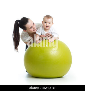 junge Mutter und ihr Baby Kind Yoga Übungen auf Gymnastik Ball isoliert auf weiß Stockfoto