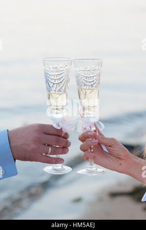 Braut und Bräutigam mit Gläsern Champagner in Händen Stockfoto