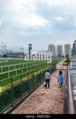 Junge asiatische paar mit Corgi in Sha Tin Racecourse in Hong Kong Stockfoto