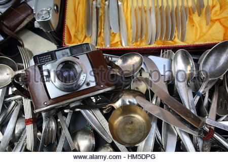Eine Kamera und alte silberne Löffel und Messer alle warf zusammen in einem Second-Hand-shop Stockfoto