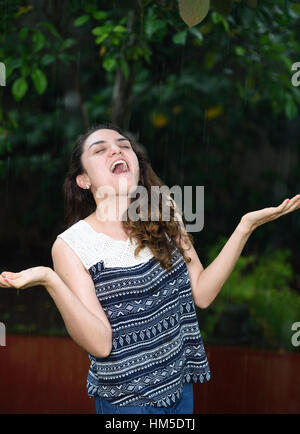 Mädchen glücklich unter schweren Dschungel Tropenregen Stockfoto