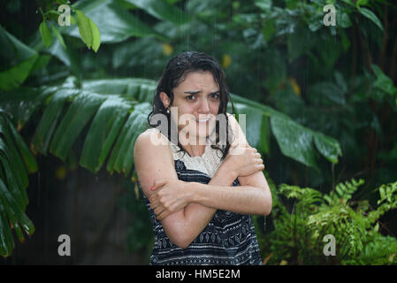 Frau fühlen sich kalt im strömenden Regen ohne Schirm Stockfoto