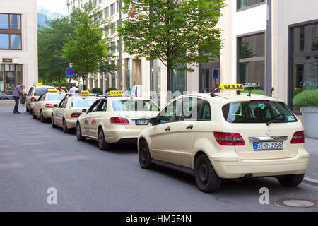 BERLIN - 23. Mai 2014: Eine Reihe von Taxis in einer Straße in Berlin. Das Taxi-Geschäft ist in Deutschland stark reguliert. Die meisten Städte haben typische Creme-col Stockfoto