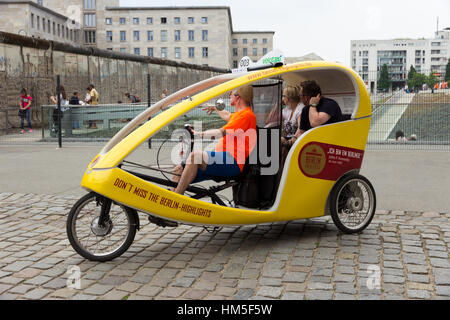 BERLIN, Deutschland - 23 Mai: Ein Taxi Bike zeigt Touristen ein Überbleibsel der Berliner Mauer am 23. Mai 2014 in Berlin, Deutschland. 5.334 Kilometer Straßen laufen Stockfoto