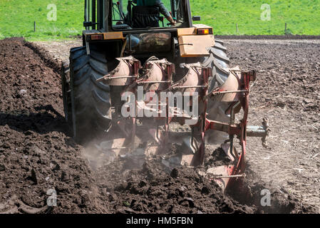 Nahaufnahme des Traktors pflügen ein Feld in Cheshire auf einem frühen sonnigen Sommertag. Stockfoto