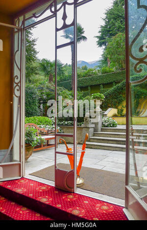 Blick auf den Garten durch die Türen eines Hotels in Comer See in Italien Stockfoto