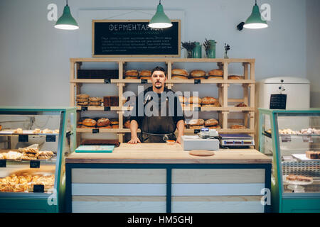 Porträt von zuversichtlich Baker stehen am Schalter in der Bäckerei Stockfoto