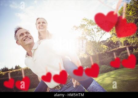 Mann, die Frau im Park Huckepack Fahrt geben Stockfoto