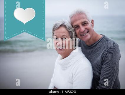 Älteres Paar umarmen einander am Strand Stockfoto