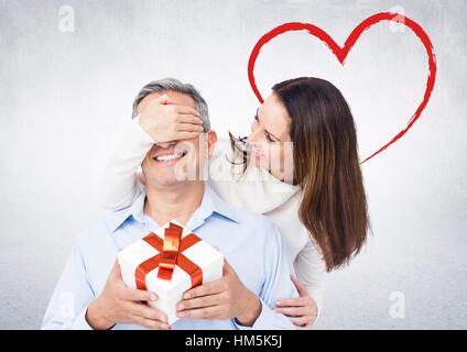 Lächelnde Frau überraschend Mann mit einem Geschenk Stockfoto