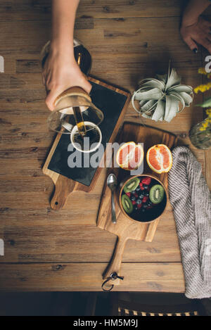 Bild der Frau gießt Kaffee in die Tasse auf Tabelle abgeschnitten Stockfoto