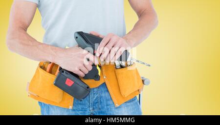 Mittleren Bereich der handliche Mann mit Werkzeuggürtel und Bohrer Stockfoto