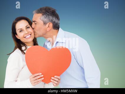 Reifer Mann küsst Frau hält ein Herz Stockfoto