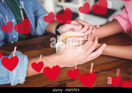 Romantisches Paar Hand in Hand bei Kaffee Stockfoto
