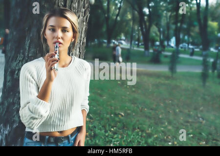 Junges Mädchen mit einer elektronischen Zigarette rauchen Stockfoto