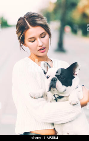 Frau und eine französische Buldog Welpen in einem park Stockfoto