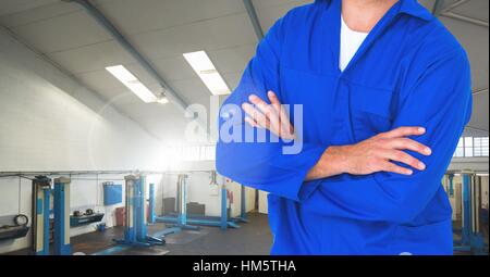 Mechaniker stehend mit Arme gekreuzt in der garage Stockfoto