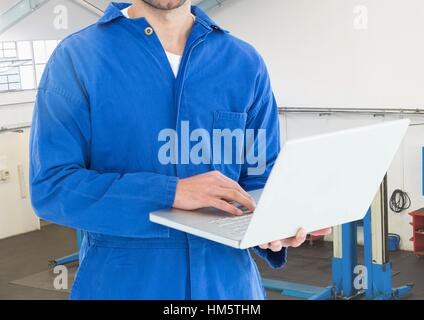 Mechaniker mit Laptop in Werkstatt Stockfoto