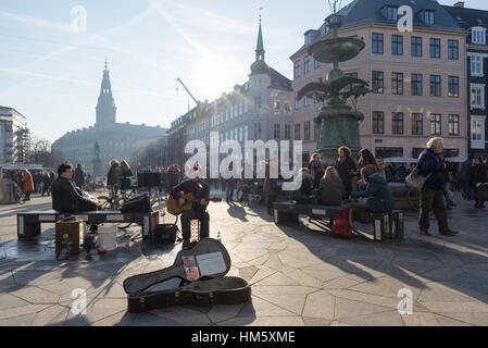 Ein Straßenmusikant führt in einer belebten HØjbro Plads, Kopenhagen, Dänemark Stockfoto