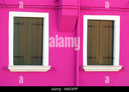 Geschlossene Fensterläden an bunten lila rosa Wand des Hauses in Burano - leuchtenden Farben der Burano, Venedig, Italien im Januar Stockfoto