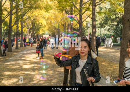 Frau bläst Seifenblasen in den Tempel der Erde Park oder Ditan Park in Peking, Volksrepublik China, Asien Stockfoto