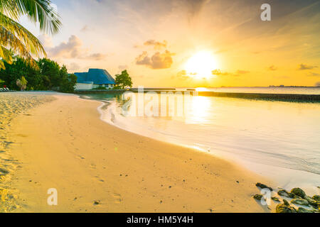 Schönen Sonnenaufgang über dem Strand mit den Wasservillen im tropischen Malediven-Insel Stockfoto
