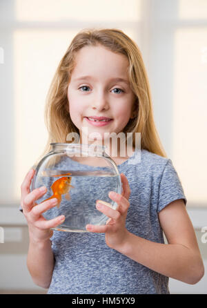 Porträt von Mädchen (6-7) Holding Goldfisch im Goldfischglas Stockfoto