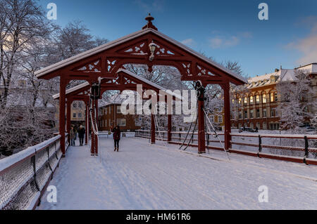 Gamle Bybro, Brücke die Altstadt über den Fluss Nid in Trondheim, Norwegen. Die Ansicht wird im Winter mit blauem Himmel gesehen. Stockfoto