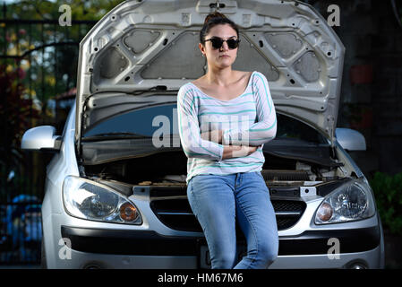 junges Mädchen Aufenthalt mit Kreuz Arme gebrochen vor Auto Stockfoto