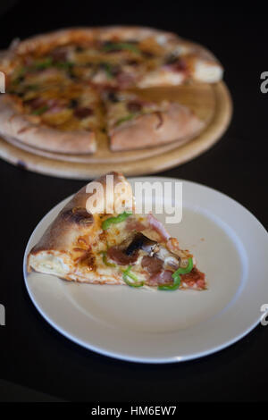 Stück Pizza auf weiße Schale Stockfoto